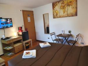 Cette chambre comprend un lit, une table et une télévision. dans l'établissement Via CASALE, à San Cataldo