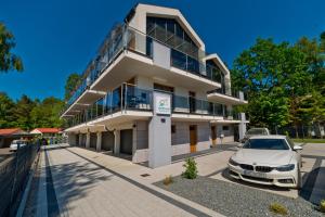 a white car parked in front of a building at BlueApart Apartland Residence in Jastarnia