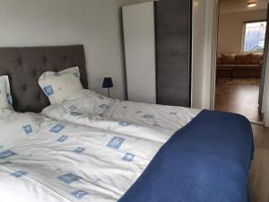 a large bed with a blue and white comforter at Centralt i Falkenberg in Falkenberg