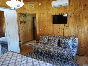 a living room with a couch and a flat screen tv at The Old House in Nesebar