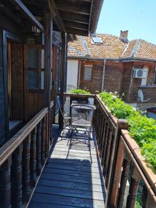 un balcón de madera con mesa y sillas. en Old House, en Nesebar