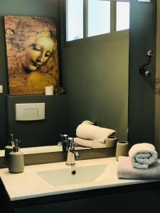 a bathroom with a sink and a large mirror at Escale face à la Loire in Chaumont-sur-Loire