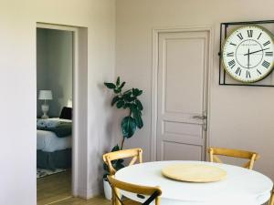 Pokój ze stołem i zegarem na ścianie w obiekcie Escale face à la Loire w mieście Chaumont-sur-Loire
