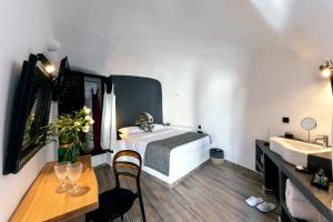 Uma cama ou camas num quarto em Pearl of Caldera Oia - Boutique Hotel by Pearl Hotel Collection