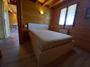 um quarto com uma cama num quarto de madeira em Chalet Sancy em Saint-Genès-Champespe