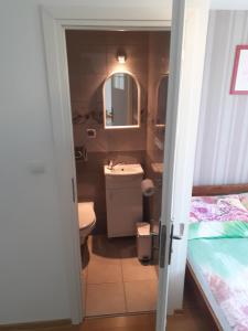 uma casa de banho com um lavatório, um WC e uma cama em Dom Gościnny "BASIA" em Jastrzebia Gora