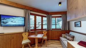 a living room with a tv and a table and chairs at Haus Lina in Sankt Anton am Arlberg
