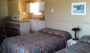 a hotel room with two beds and a kitchen at Motel Royal in Cabano