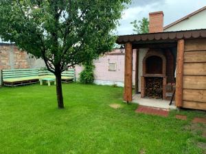 a pavilion with a tree and a bench in a yard at LIKE HOME in Râşnov