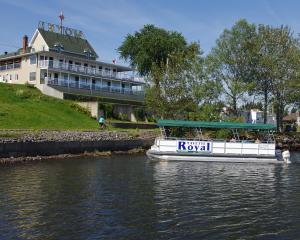 a boat in the water in front of a building at Motel Royal in Cabano