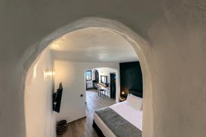Uma televisão e/ou sistema de entretenimento em Pearl of Caldera Oia - Boutique Hotel by Pearl Hotel Collection