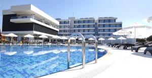 un hotel con piscina frente a un edificio en TEZMADRA HOTEL, en Burhaniye