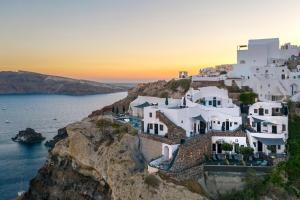 um grupo de casas brancas num penhasco em Pearl of Caldera Oia - Boutique Hotel by Pearl Hotel Collection em Oia
