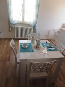 a dining room table with chairs and a white table and chairsktop at Rosmat's house in Conversano