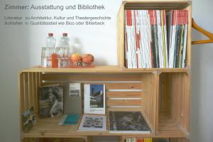 een houten boekenplank met boeken en platen bij BnB 5430 in Wettingen