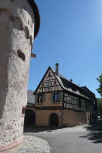 una grande casa con un edificio sullo sfondo di Au Petit Paradis ad Ammerschwihr