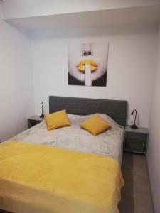 sypialnia z łóżkiem z 2 żółtymi poduszkami w obiekcie Kalamaja Garden w Tallinnie