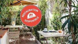 a sign for a restaurant with two tables and a waterfall at Hôtel Alizé in Toulouse