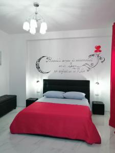 a bedroom with a red bed with a sign on the wall at Summer in Sud in Porto Cesareo