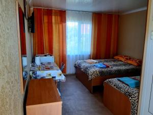 a small room with two beds and a desk and a table at Зюйд in Gribovka