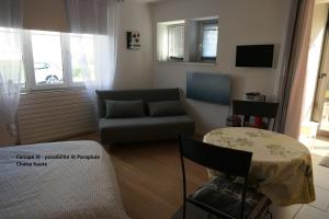a living room with a couch and a table at Au Petit Paradis in Ammerschwihr