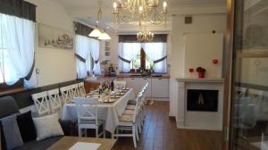 a dining room and kitchen with a white table and chairs at Lawendowy Dworek in Laskówka