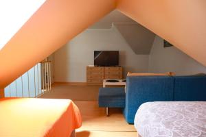 a attic room with a bed and a tv at Maria Apartment Tolli põik in Kuressaare