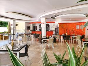 a restaurant with tables and chairs and red walls at Hotel Posada Campestre San Gil in San Gil