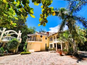 a house with a palm tree in front of it at Hotel Posada Campestre San Gil in San Gil