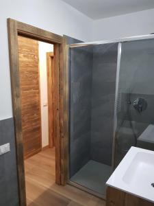 a shower with a glass door in a bathroom at Casa Sonia in Canazei