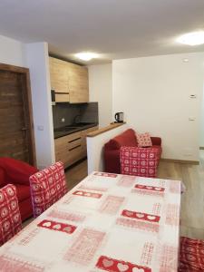 een kamer met een tafel en 2 stoelen en een keuken bij Casa Sonia in Canazei