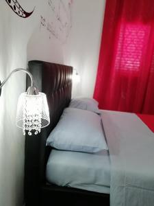 um quarto com uma cama com um candeeiro ao lado em Summer in Sud em Porto Cesareo