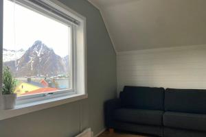 a couch sitting in a room with a window at Koselig leilighet sentralt i Svolvær in Svolvær