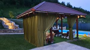 a gazebo in a yard next to a pool at Villa Panorama in Bihać