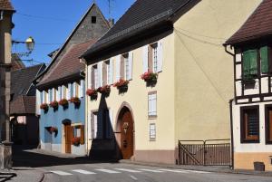 L'Hadestal في Hattstatt: مبنى فيه علب ورد على نوافذ شارع