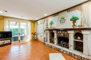 a large living room with a stone fireplace at Villa Simonetta in Fregene