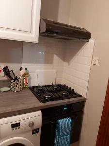 a kitchen with a stove top oven in a kitchen at Foot of the Mournes - Cottage - Sleeps 4 - Parking in Newry