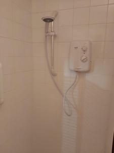 a shower in a white tiled bathroom with a shower head at Foot of the Mournes - Cottage - Sleeps 4 - Parking in Newry +25 photos