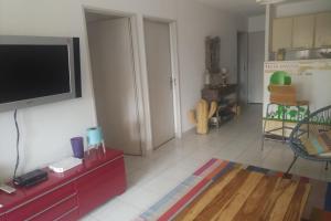 un salon avec une télévision à écran plat sur un mur dans l'établissement RESIDENCE SANTA REGINA, à Calvi