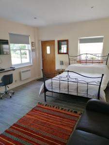 a bedroom with a bed and a desk and a couch at Riverside in Chepstow