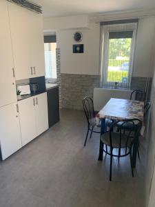 a kitchen with a table and chairs in a room at Komo Apartment in Bük