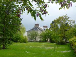 une vieille maison au milieu d'une cour dans l'établissement Cèdre et Charme, à Saint-Branchs