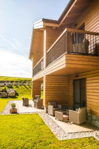a house with a deck with chairs and a balcony at Apartmány Tatry Žiarce in Liptovský Mikuláš
