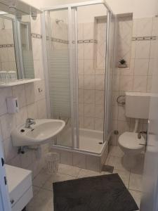 uma casa de banho com um chuveiro, um lavatório e um WC. em Guest House Stefica em Hvar
