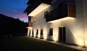 a building with lights on the side of it at night at Il giardino di Anna - Appartamento 1 in Fai della Paganella