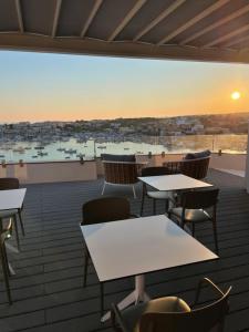 a balcony with tables and chairs and a view of a harbor at B&B Giro Di Boa in Lampedusa
