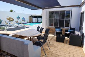 eine Terrasse mit einem Tisch, Stühlen und einem Pool in der Unterkunft Villa Lua Mar in Fuseta