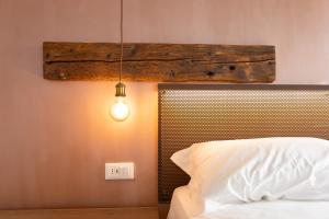 ein Schlafzimmer mit einem weißen Bett und einer Leuchte in der Unterkunft Casa San Cristoforo in Chioggia