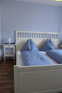 a bedroom with a bed with blue pillows on it at Apartment Seber in Stuhlfelden