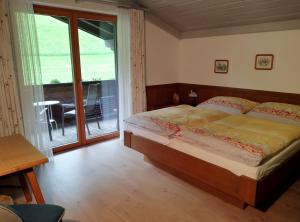 een slaapkamer met een bed en een glazen schuifdeur bij Haus Kieler in Schladming